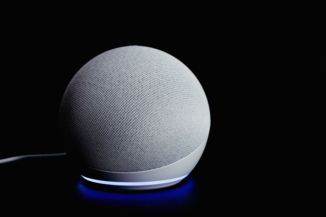 Contemporary smart speaker with a glowing ring, displayed against a dark backdrop.